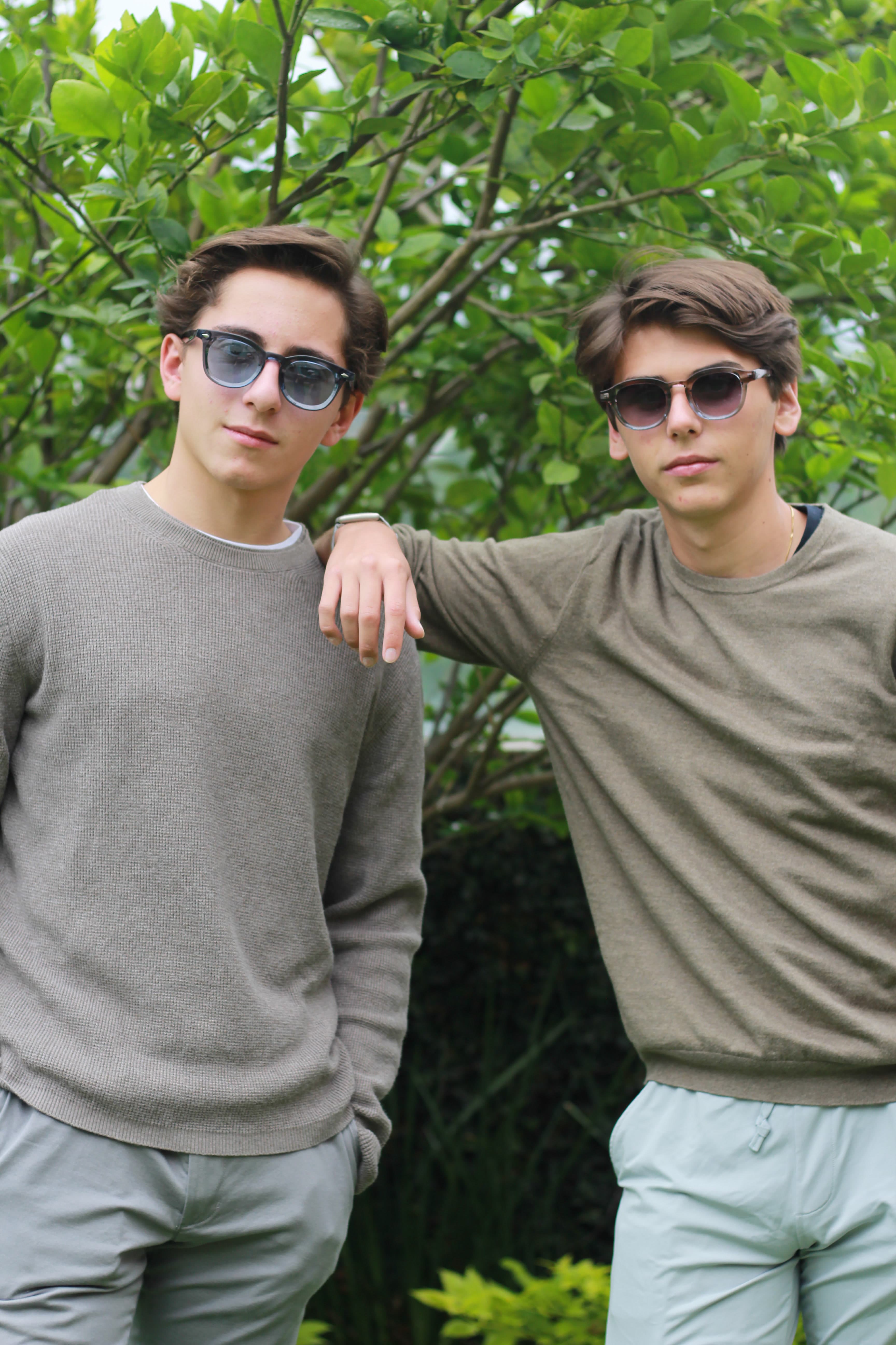 Two models in OPHRA sunglasses against green foliage