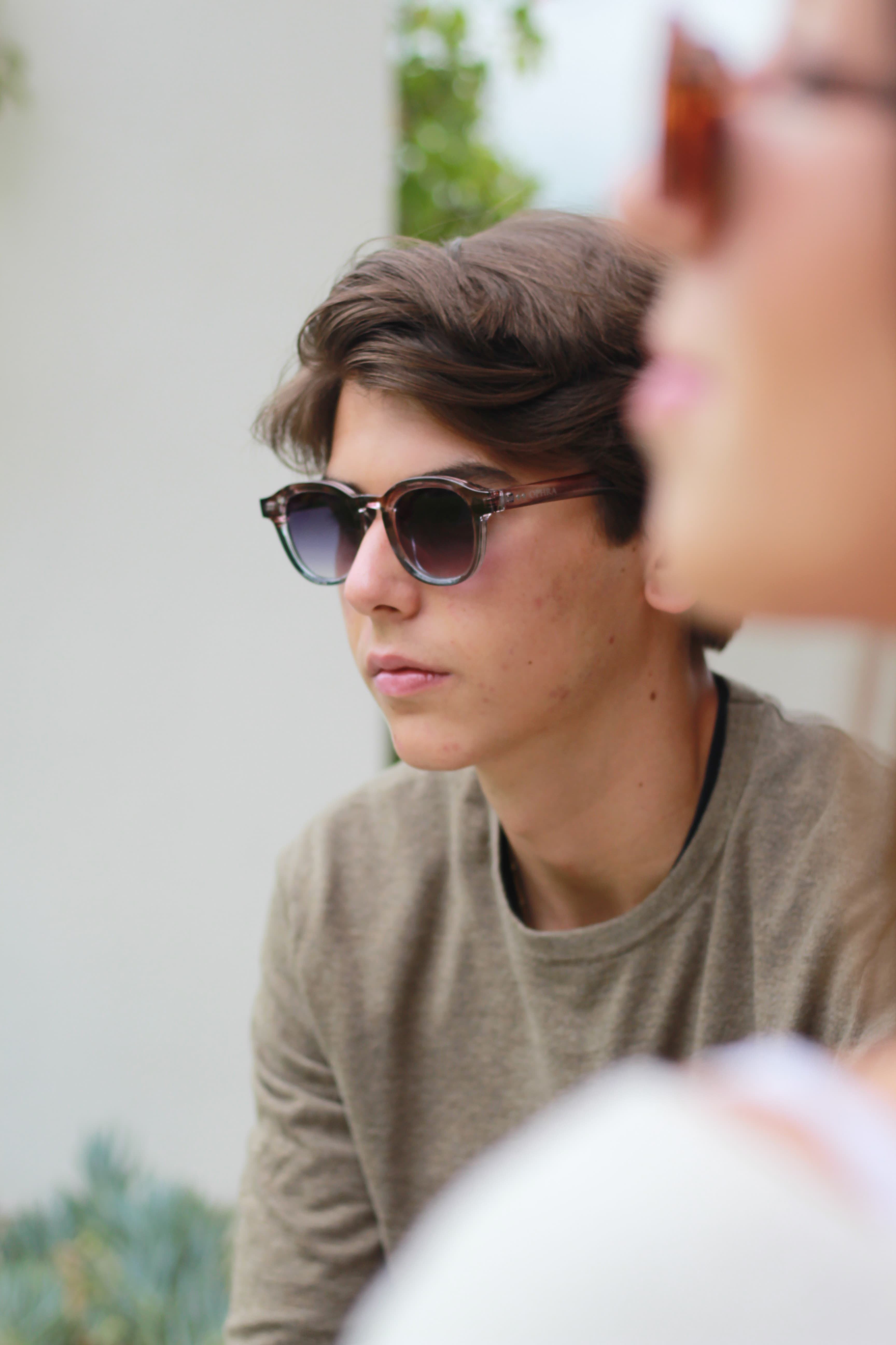 Model reclining in OPHRA translucent round sunglasses