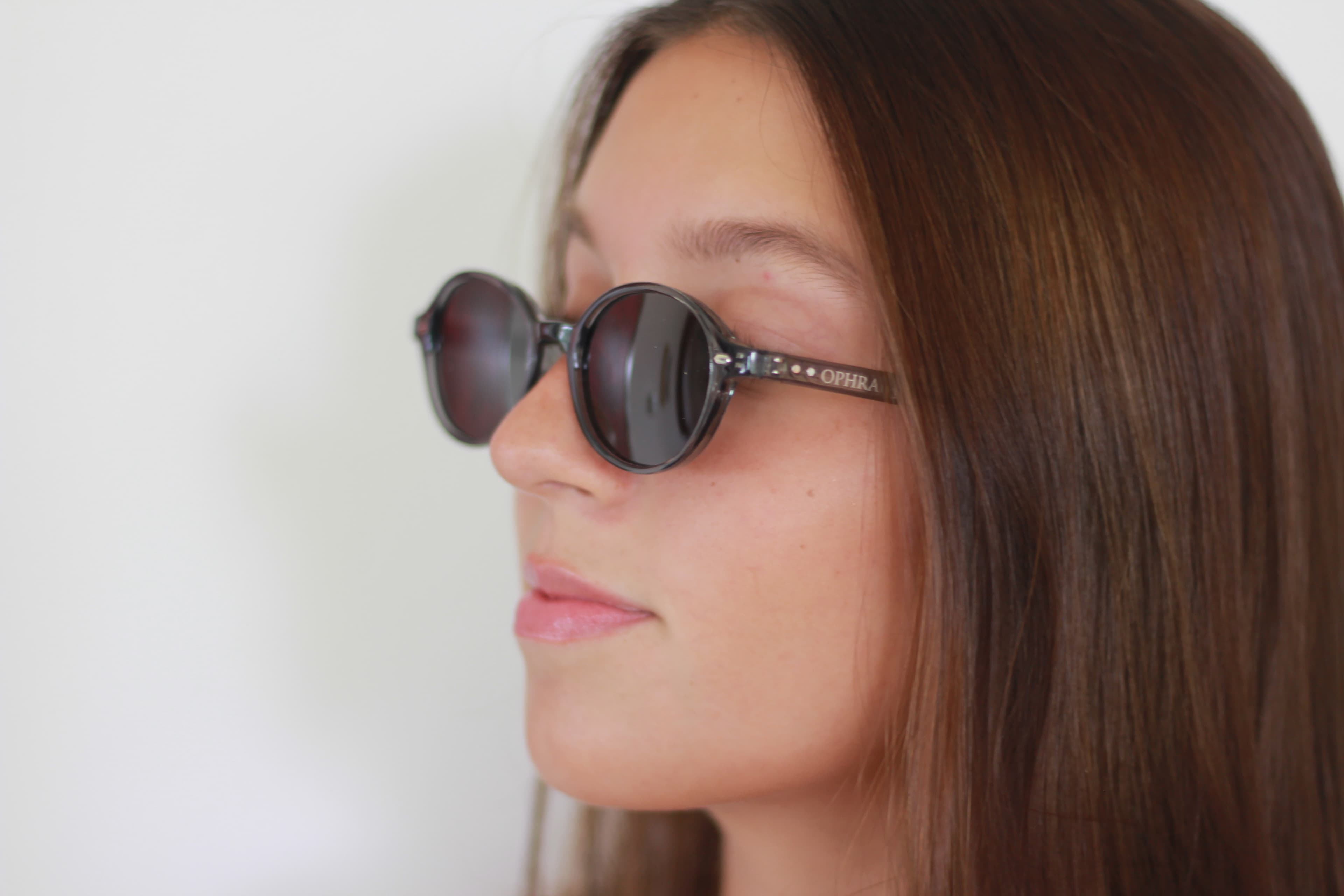 Side-profile portrait of a model in OPHRA round sunglasses