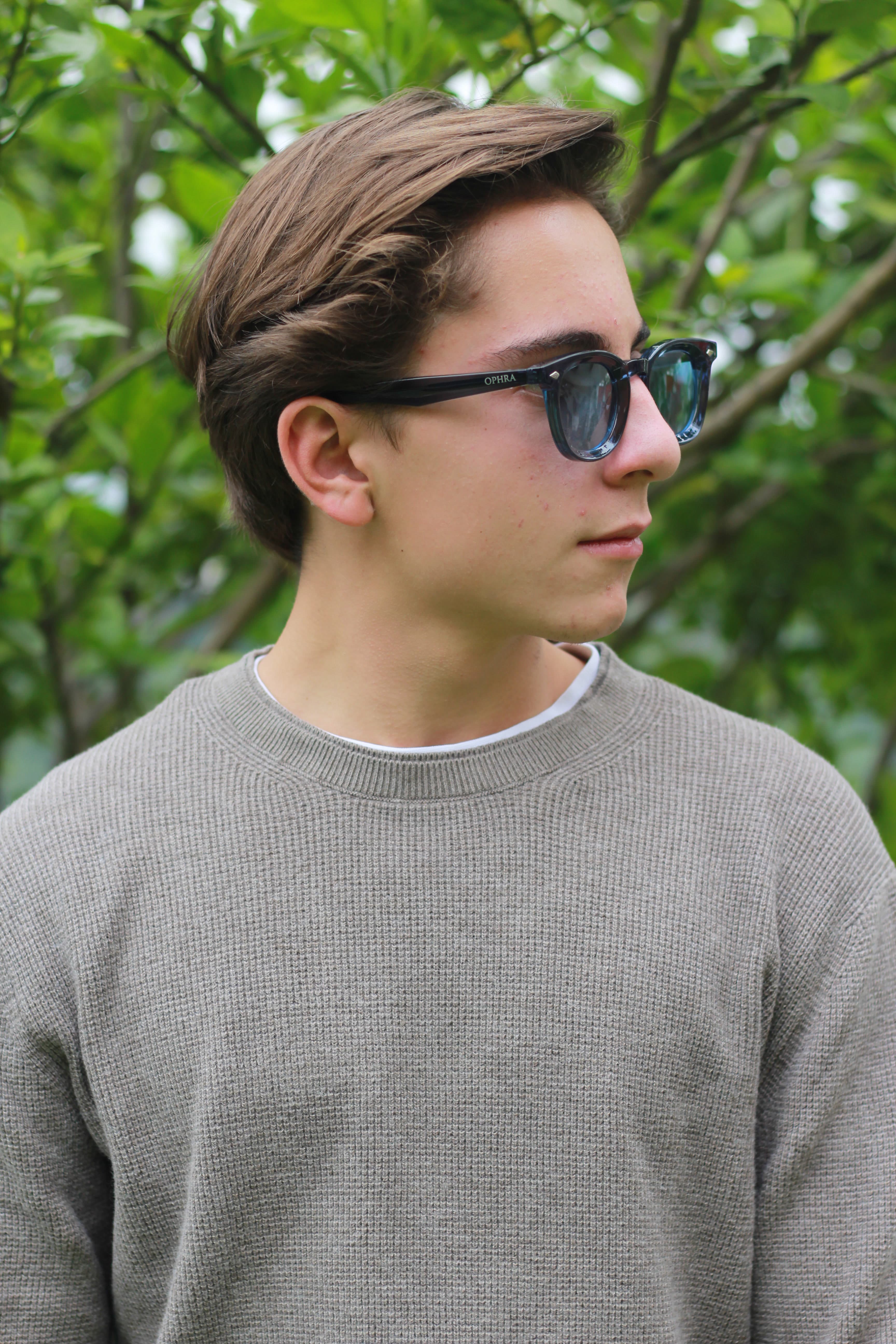Model in OPHRA sunglasses against green foliage