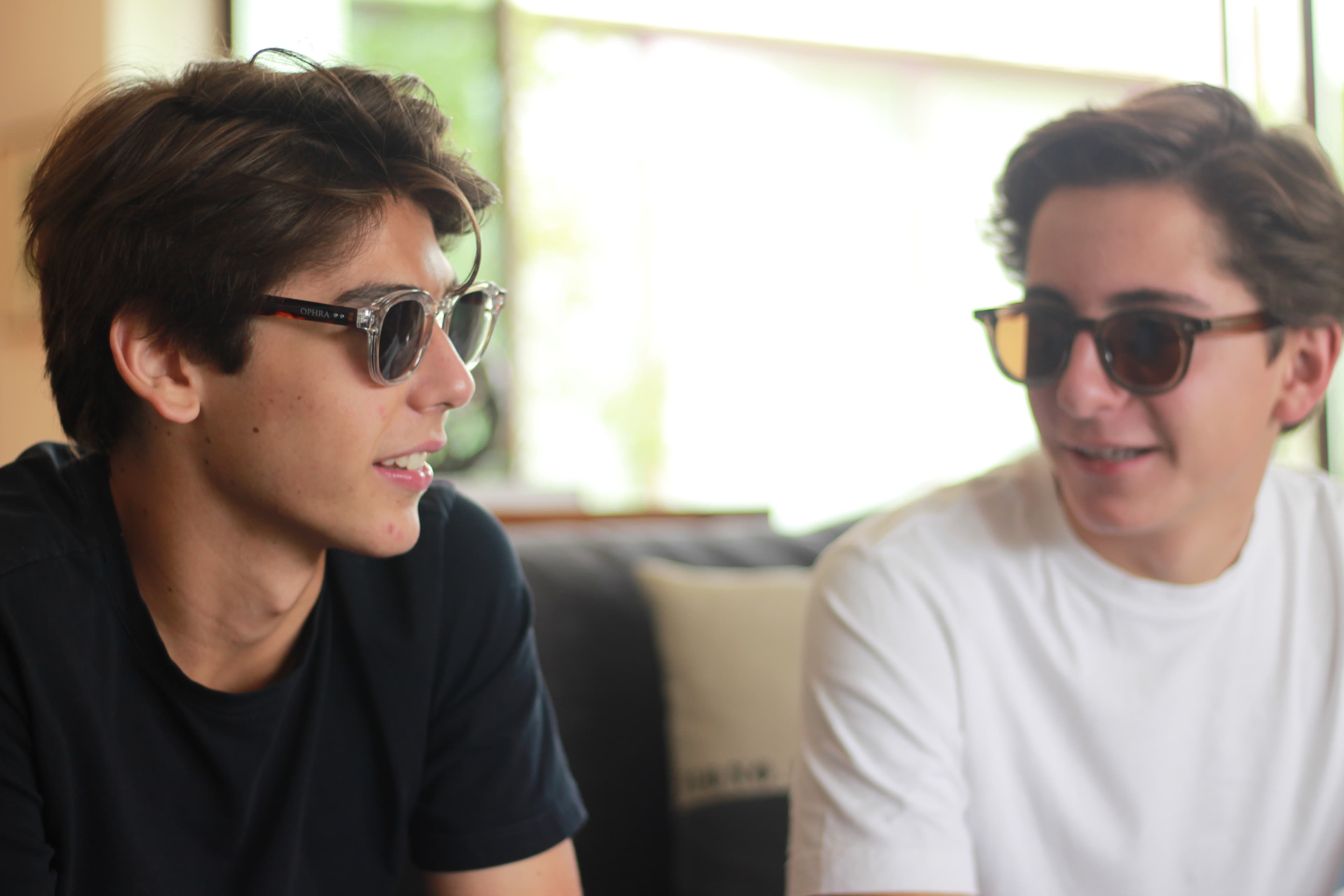 Two friends wearing OPHRA sunglasses in conversation