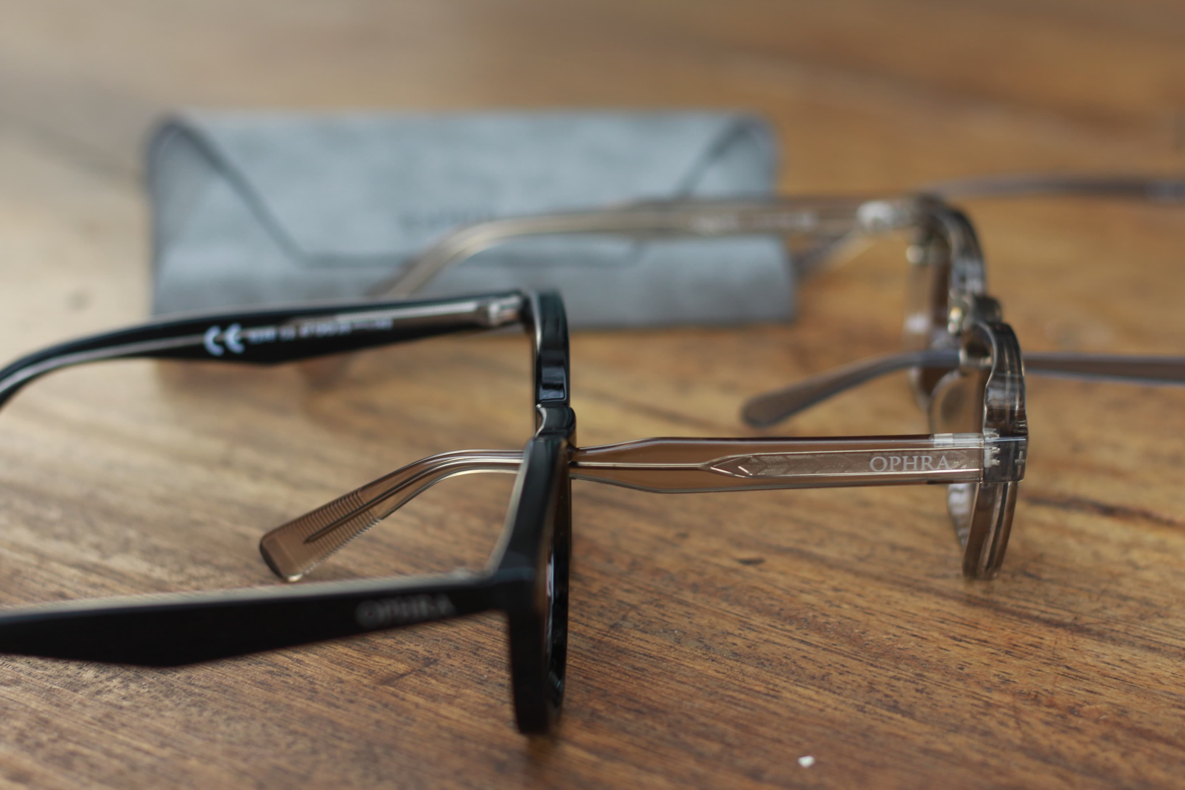 Two pairs of OPHRA sunglasses showing engraved temples